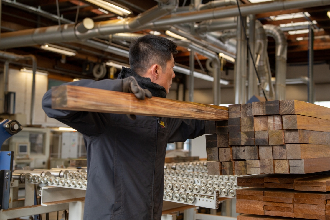 An employee working with wooden planks.