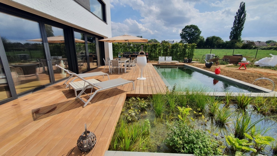 Terrasse en bois avec chaises longues et piscine.
