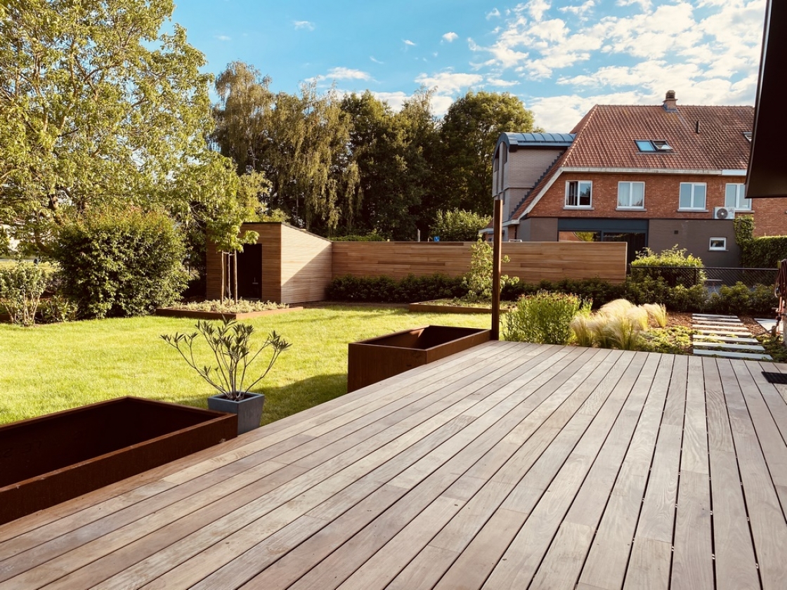 Een tuin met een houten terrasvloer.